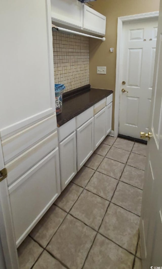1717 Perdiz Covey Ct, Myrtle Beach, SC 29588 - kitchen featuring backsplash, dark countertops, white cabinetry, and light tile patterned flooring