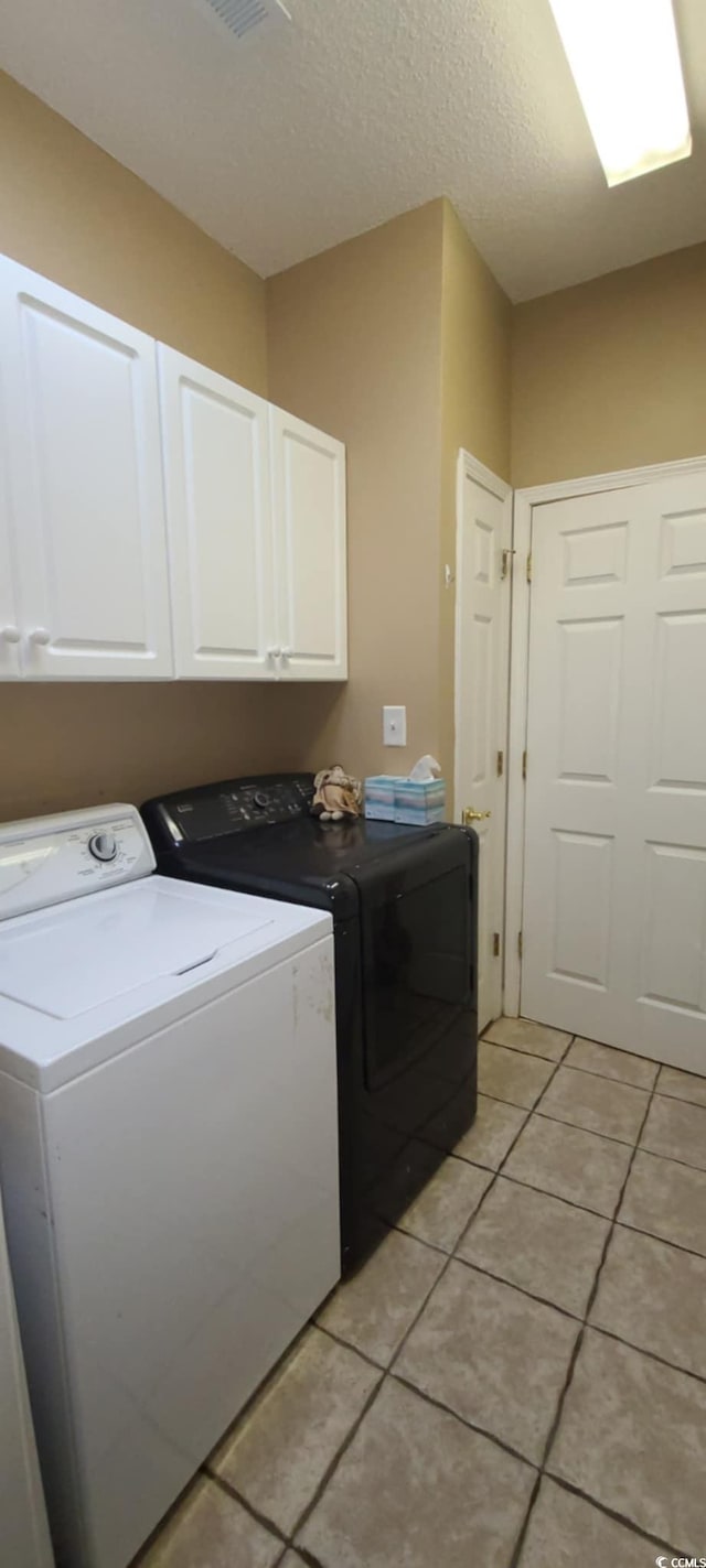 1717 Perdiz Covey Ct, Myrtle Beach, SC 29588 - laundry area with cabinet space, washer and clothes dryer, light tile patterned floors, and a textured ceiling