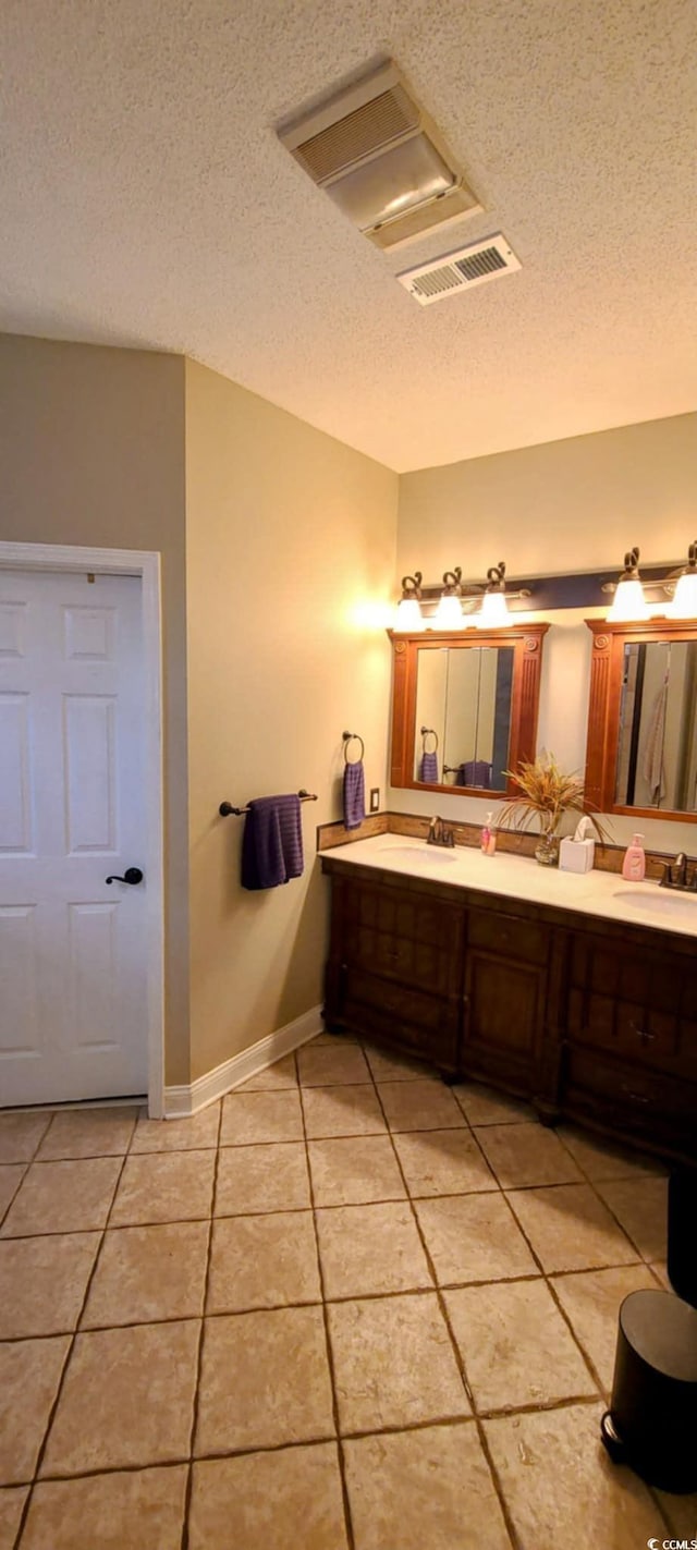 1717 Perdiz Covey Ct, Myrtle Beach, SC 29588 - bathroom featuring a textured ceiling, tile patterned floors, double vanity, and baseboards