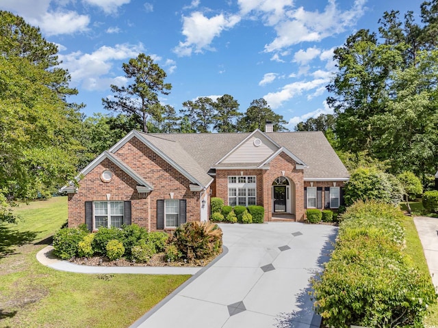 1004 Addington Ct, Murrells Inlet, SC 29576 - traditional-style home featuring brick siding, a front yard, a chimney, and a shingled roof