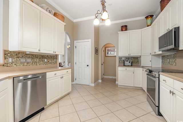 1004 Addington Ct, Murrells Inlet, SC 29576 - kitchen with stainless steel appliances, arched walkways, backsplash, light tile patterned flooring, and ornamental molding