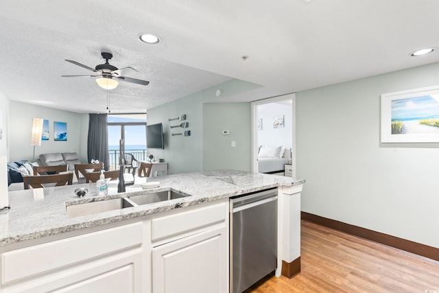 205 74th Ave N Unit 1104, Myrtle Beach, SC 29572 - kitchen featuring stainless steel dishwasher, a sink, open floor plan, a ceiling fan, and light stone counters