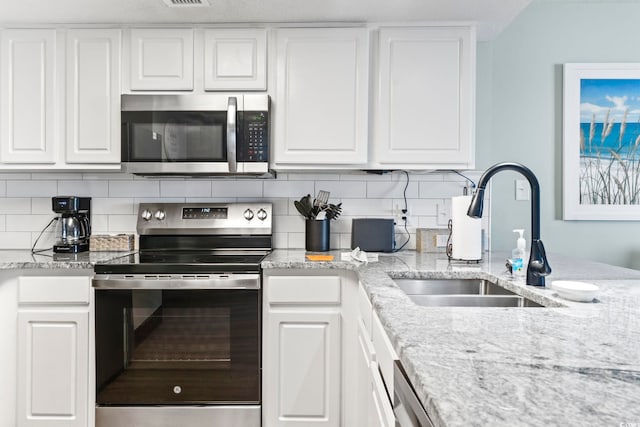 205 74th Ave N Unit 1104, Myrtle Beach, SC 29572 - kitchen featuring stainless steel appliances, a sink, backsplash, and white cabinets