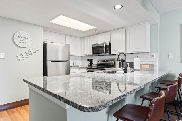 205 74th Ave N Unit 1104, Myrtle Beach, SC 29572 - kitchen with stainless steel appliances, a peninsula, tasteful backsplash, dark stone counters, and recessed lighting