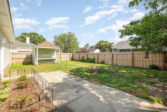 706 Chippendale Dr, Myrtle Beach, SC 29588 - view of yard featuring a storage shed, a fire pit, a fenced backyard, an outbuilding, and a patio area