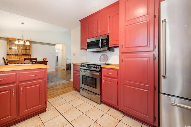 706 Chippendale Dr, Myrtle Beach, SC 29588 - kitchen featuring pendant lighting, an inviting chandelier, light tile patterned flooring, vaulted ceiling, and stainless steel appliances