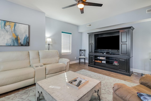 living room featuring visible vents, wood finished floors, baseboards, and ceiling fan
