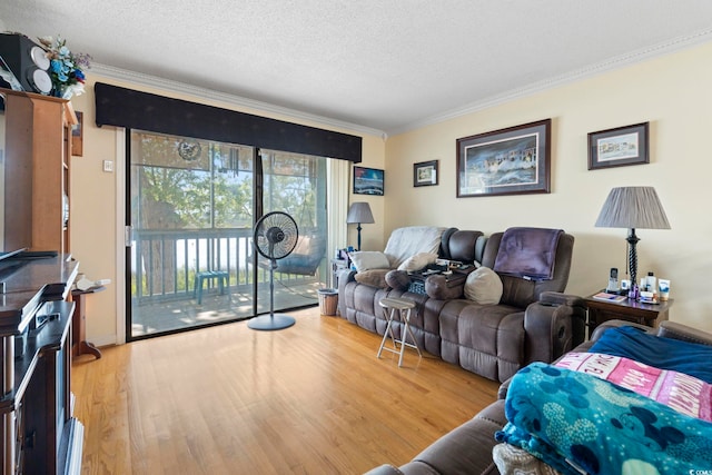living room with ornamental molding, a textured ceiling, and wood finished floors