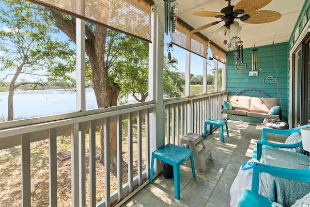sunroom with a water view and ceiling fan
