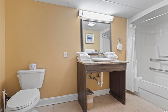 bathroom featuring a sink, tile patterned floors, toilet, shower / bathtub combination with curtain, and baseboards