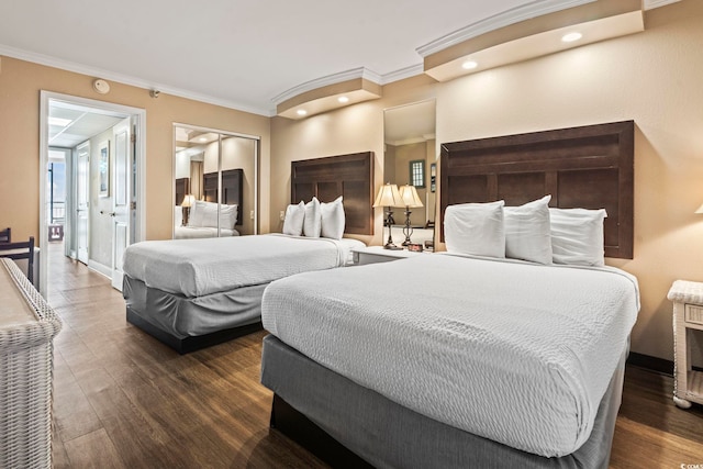 bedroom featuring crown molding, dark wood-style flooring, and a closet