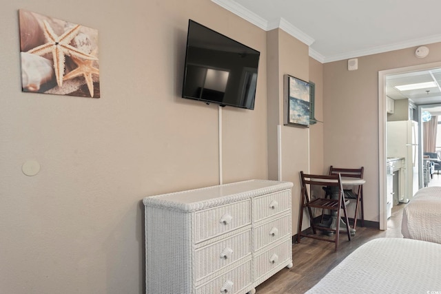 bedroom with ornamental molding, dark wood-style floors, and baseboards