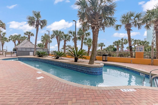 community pool featuring fence and a patio area