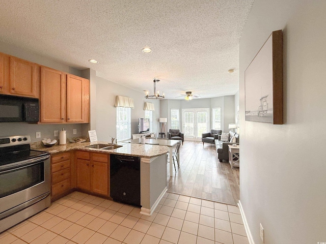 kitchen with a peninsula, a textured ceiling, open floor plan, and black appliances