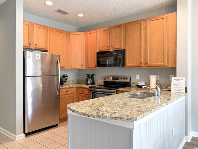 kitchen featuring a peninsula, a sink, baseboards, appliances with stainless steel finishes, and recessed lighting