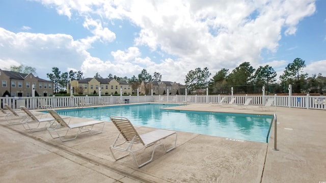 community pool featuring fence and a patio