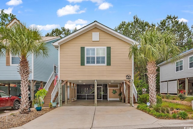 coastal inspired home featuring stairway, a carport, and driveway