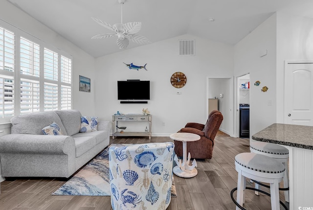 living room with wood finished floors, ceiling fan, high vaulted ceiling, and baseboards