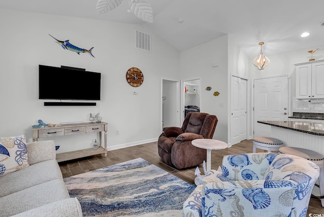 living area with wood finished floors, high vaulted ceiling, baseboards, and recessed lighting