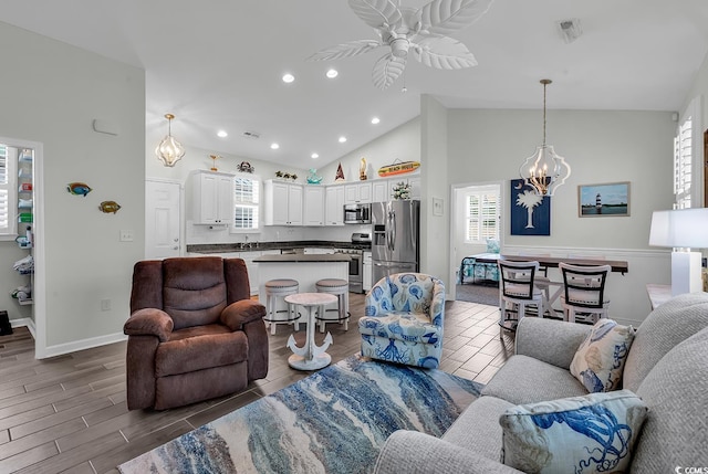 living area featuring ceiling fan, recessed lighting, a chandelier, baseboards, and high vaulted ceiling