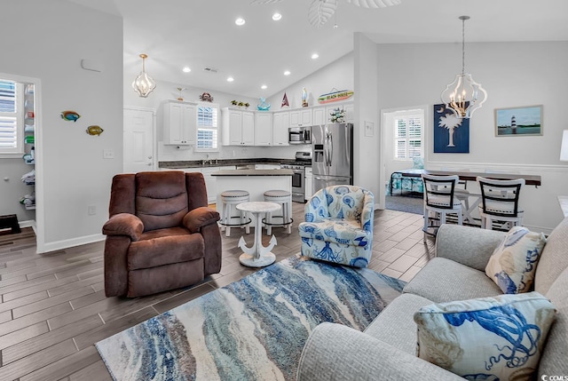 living area featuring high vaulted ceiling, a chandelier, wood finished floors, recessed lighting, and baseboards