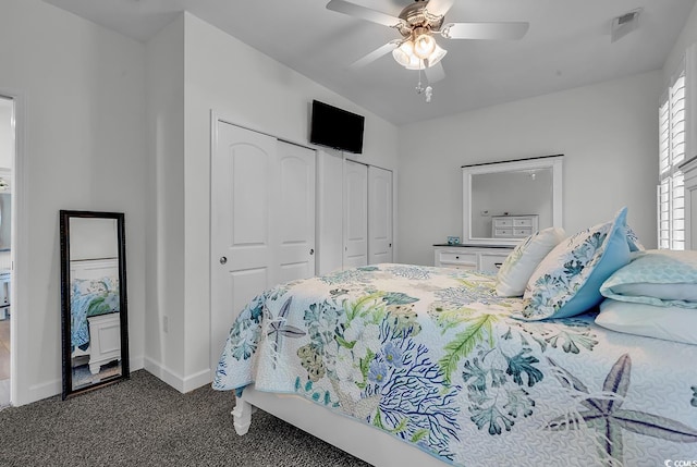 bedroom with two closets, carpet flooring, baseboards, and a ceiling fan