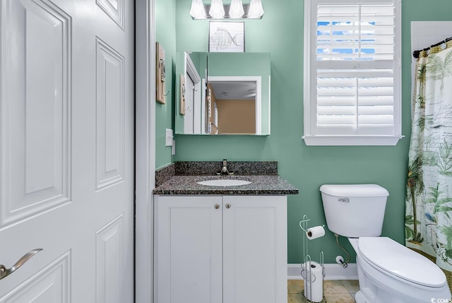bathroom featuring toilet, vanity, and baseboards