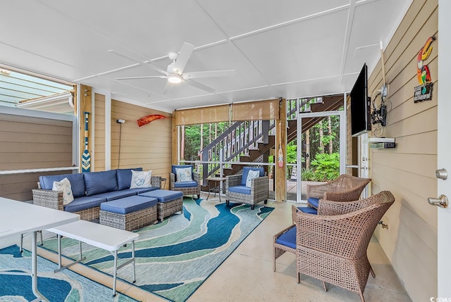 sunroom featuring ceiling fan and an outdoor living space
