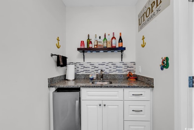 indoor wet bar featuring freestanding refrigerator and decorative backsplash