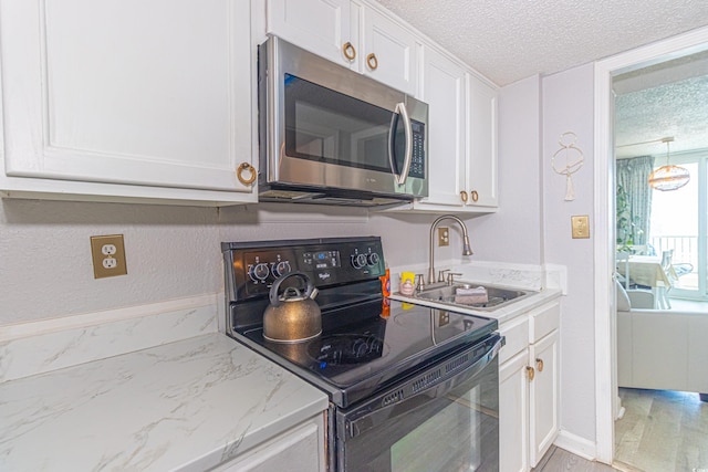 200 76th Ave N Unit 408, Myrtle Beach, SC 29572 - kitchen with a sink, black range with electric stovetop, white cabinets, a textured ceiling, and stainless steel microwave