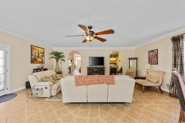 living room featuring arched walkways, healthy amount of natural light, a ceiling fan, ornamental molding, and light tile patterned flooring