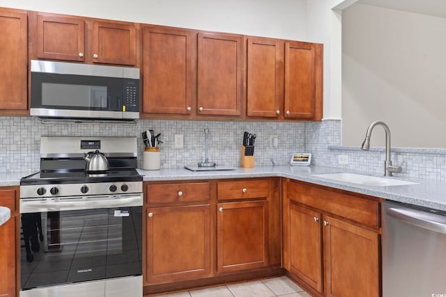 157 Olde Towne Way Unit 4, Myrtle Beach, SC 29588 - kitchen featuring a sink, stainless steel appliances, tasteful backsplash, light stone counters, and light tile patterned floors
