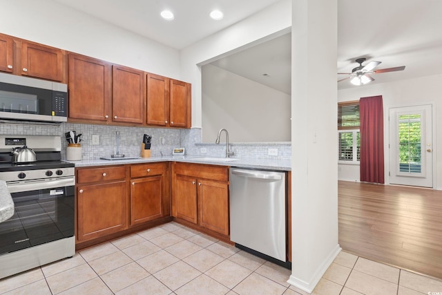 157 Olde Towne Way Unit 4, Myrtle Beach, SC 29588 - kitchen with a sink, ceiling fan, decorative backsplash, light tile patterned floors, and appliances with stainless steel finishes