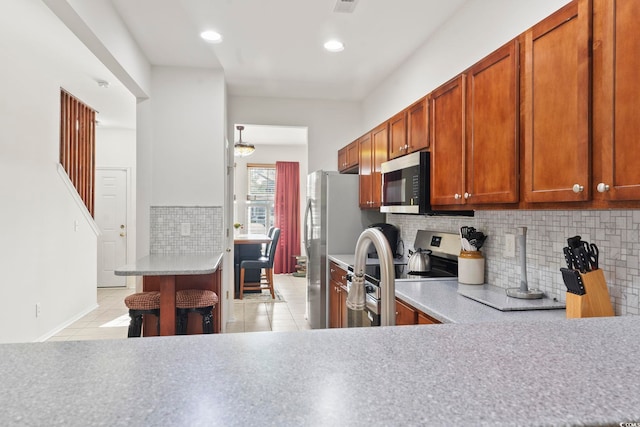 157 Olde Towne Way Unit 4, Myrtle Beach, SC 29588 - kitchen with brown cabinetry, light countertops, tasteful backsplash, and appliances with stainless steel finishes