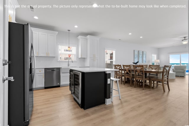 kitchen featuring a center island, backsplash, light countertops, appliances with stainless steel finishes, and recessed lighting