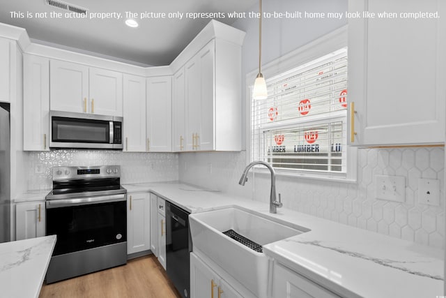 kitchen with a sink, stainless steel appliances, white cabinets, visible vents, and tasteful backsplash