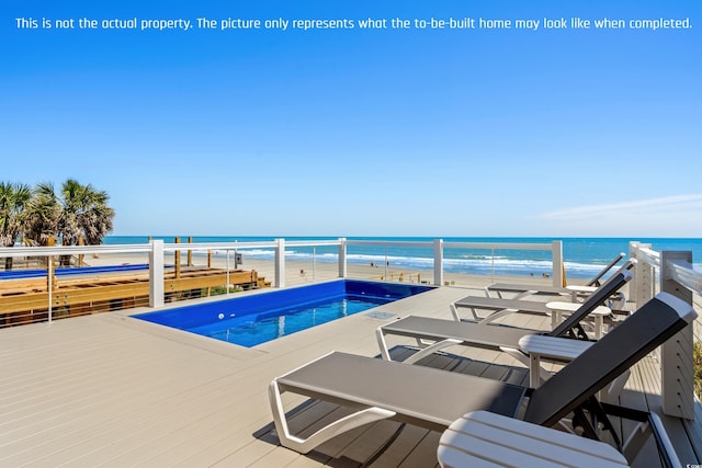 pool with a deck with water view and a beach view