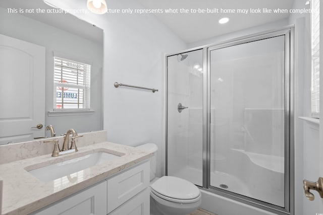 bathroom with a stall shower, vanity, and toilet