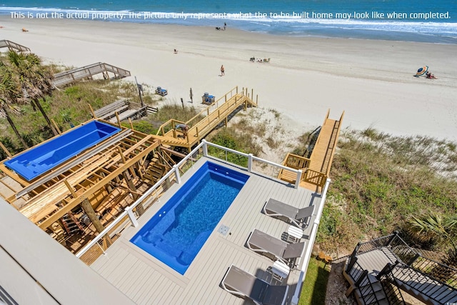 view of pool with a water view and a beach view