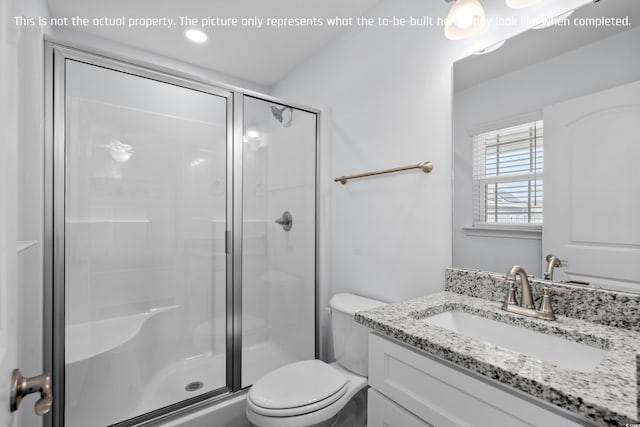 bathroom featuring a shower stall, vanity, and toilet