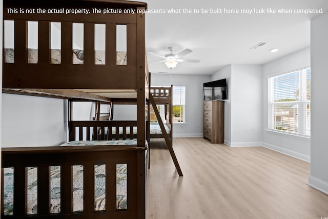 unfurnished bedroom with wood finished floors, baseboards, and multiple windows