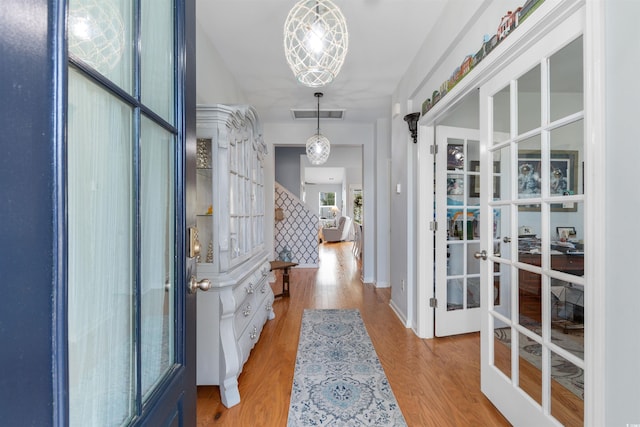 interior space featuring wood finished floors, visible vents, and french doors