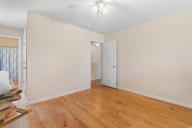 empty room featuring ceiling fan, baseboards, and light wood-type flooring
