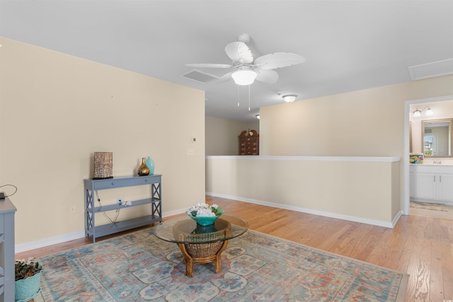 living area with ceiling fan, baseboards, visible vents, and wood finished floors