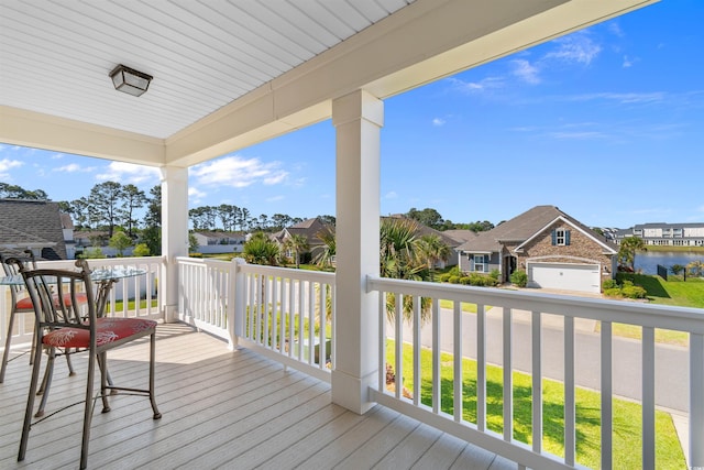 wooden terrace featuring a water view and a residential view