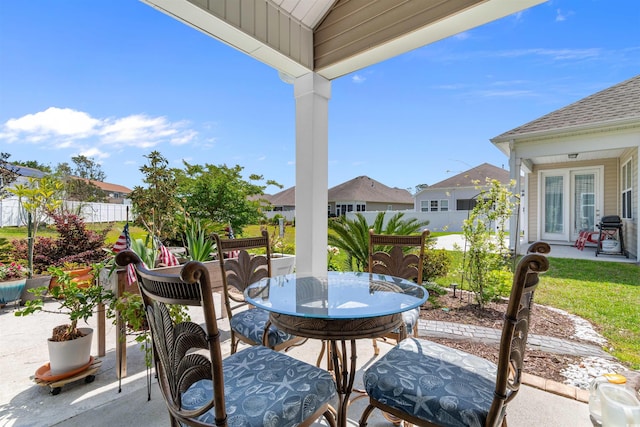 view of patio / terrace featuring a residential view, outdoor dining area, and fence