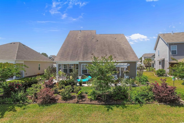 rear view of property featuring a lawn, a patio, and a pergola