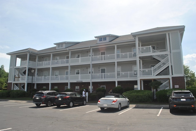 view of apartment building / complex featuring uncovered parking