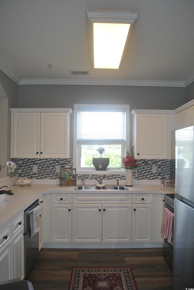 kitchen featuring stainless steel appliances, a sink, white cabinets, dark wood finished floors, and crown molding