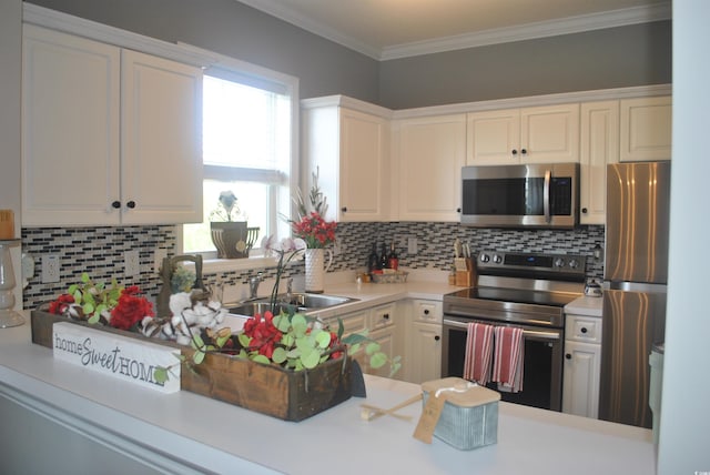 kitchen with appliances with stainless steel finishes, a sink, light countertops, decorative backsplash, and white cabinetry